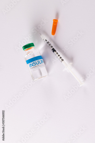 Insulin vial and uncapped syringe on white background with copy space photo