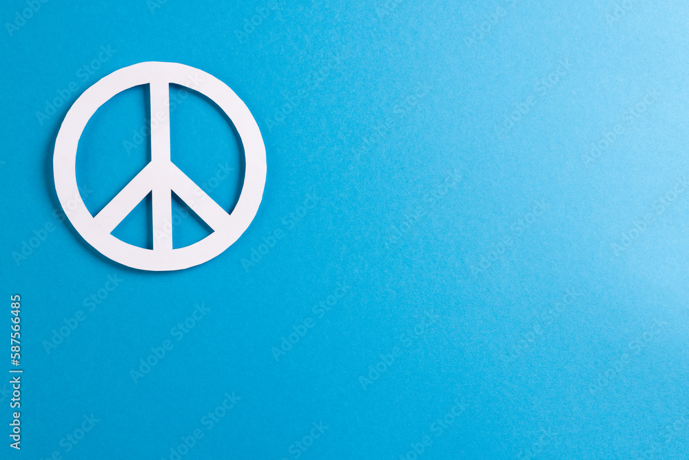 High angle view of white peace sign with copy space on blue background High angle view of white peace sign with copy space on blue background