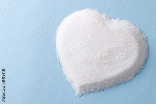 Sugar in heart shape on blue background