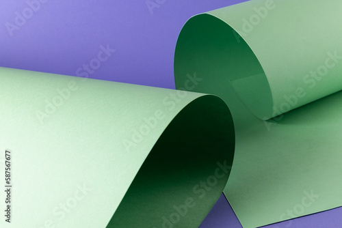 Close up of green paper on purple background with copy space