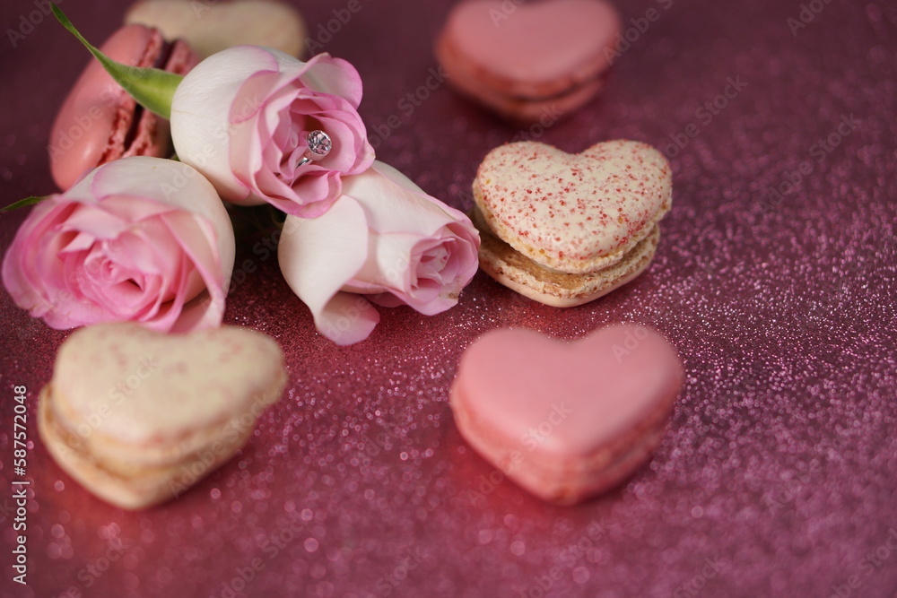 Heart-shaped macarons with roses on glittery pink background, Valentines day Heart-shaped macarons with roses on glittery pink background, Valentines day