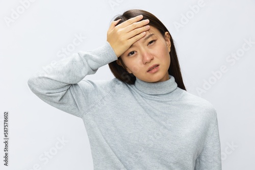 Asian woman holding her hand to her head for severe headache, migraine white background
