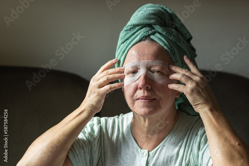 Beautiful senior woman with collagen eye mask for antiaging beauty and facial wellness. Granny applying eye patches.