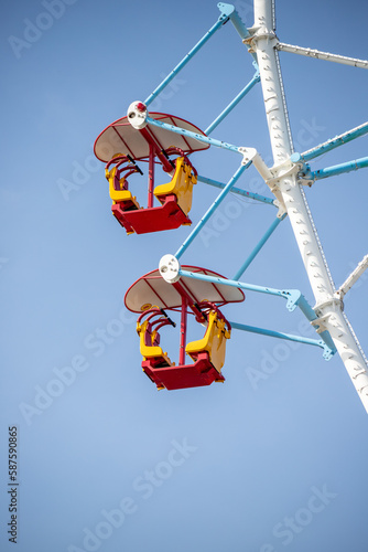 Ferris wheel, booths against the blue sky.