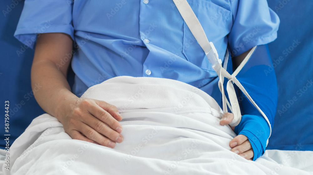 Cropped image of doctor in uniform with stethoscope using tablet standing in hospital with patient lying in bed on background Operator checks patient information on digital tablet