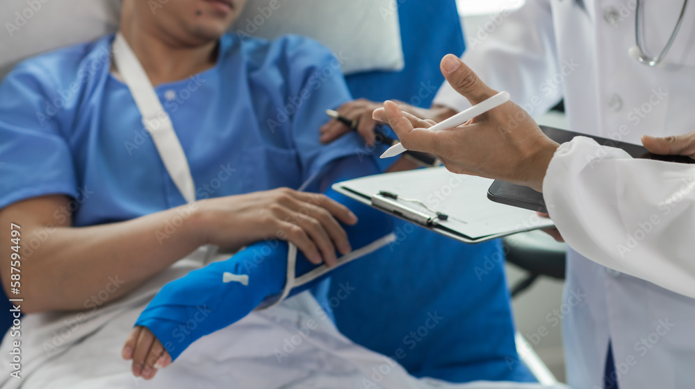 Cropped image of doctor in uniform with stethoscope using tablet standing in hospital with patient lying in bed on background Operator checks patient information on digital tablet Cropped image of doctor in uniform with stethoscope using tablet standing in hospital with patient lying in bed on background Operator checks patient information on digital tablet