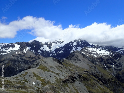 Rocky alpine hiking with snow covered mountains in the background in Nelson Lakes National Park in the south island of New Zealand
