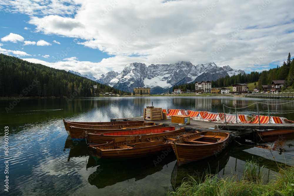 Misurina See in den Dolomiten bei Cortina mit bunten Booten, Bergmassiv und Wolke im Frühling.