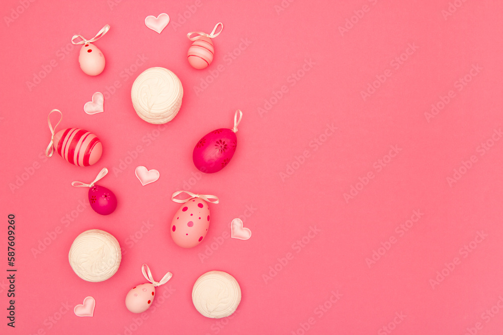 Easter eggs, small hearts and big marshmallows on pink background provide ample space for copying
