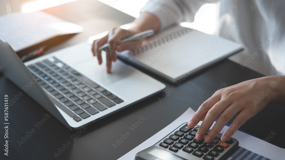 Businesswoman working at office, using calculator to calculate financial report, sales data, with laptop computer and business document on office table, close up. Business, finance and investment Businesswoman working at office, using calculator to calculate financial report, sales data, with laptop computer and business document on office table, close up. Business, finance and investment