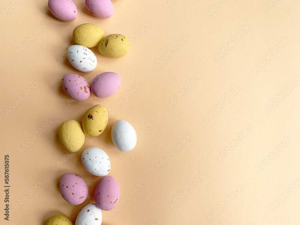 Easter quail eggs over beige background. Spring holidays concept with copy space. Easter decorative composition of chocolate eggs. Top view