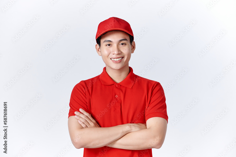 Smiling delivery man in red uniform standing with arm crossed - isolated on white background Smiling delivery man in red uniform standing with arm crossed - isolated on white background