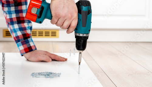 Wallpaper Mural the furniture collector assembles the cabinet with a screwdriver Torontodigital.ca