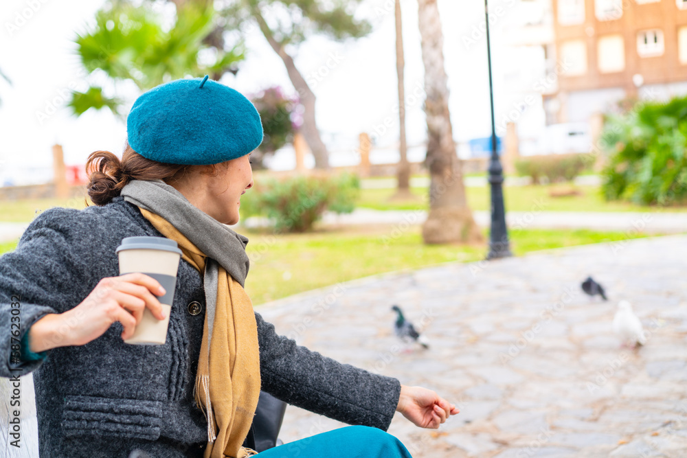 Brunette woman holding a take away coffee at outdoors Brunette woman holding a take away coffee at outdoors
