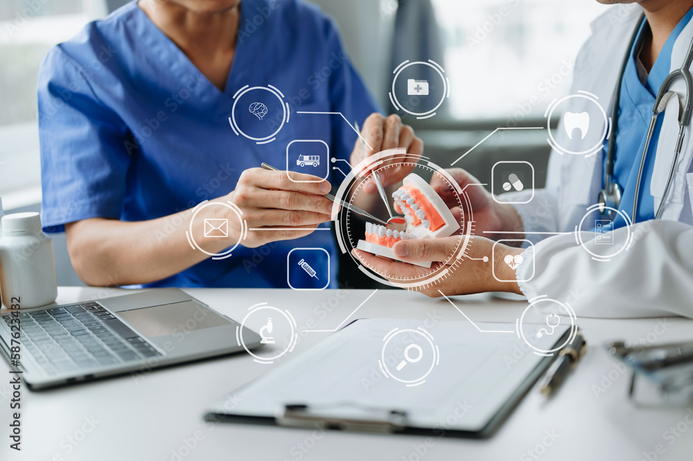 Dentist sitting at table with jaw samples tooth model and working with