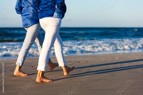 Two middle-aged women walking on beach 