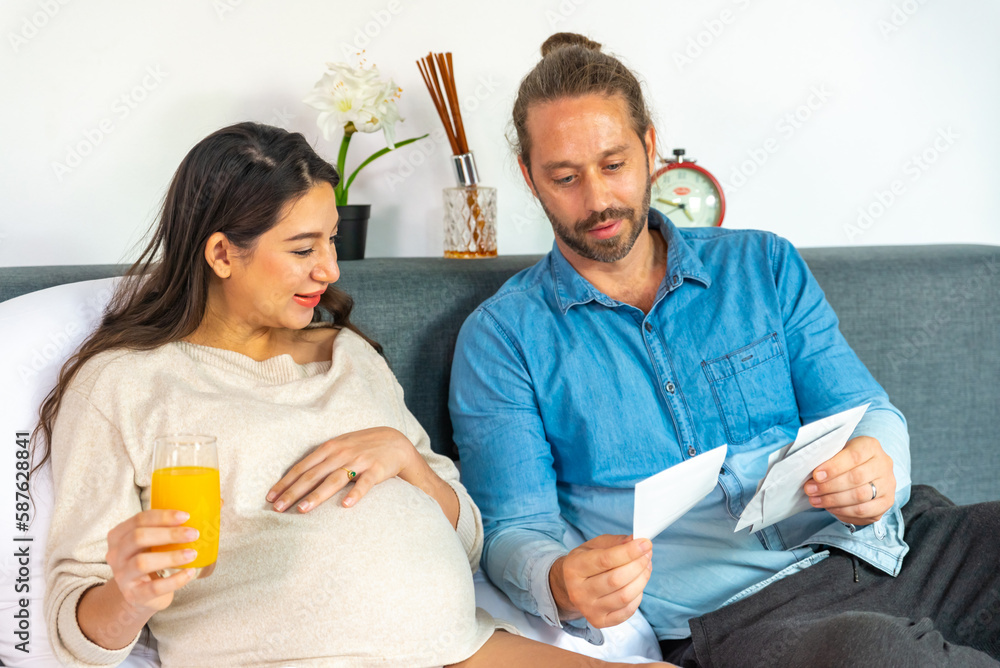 Foto de Caucasian pregnancy woman drinking orange juice during looking ultrasound photo of her