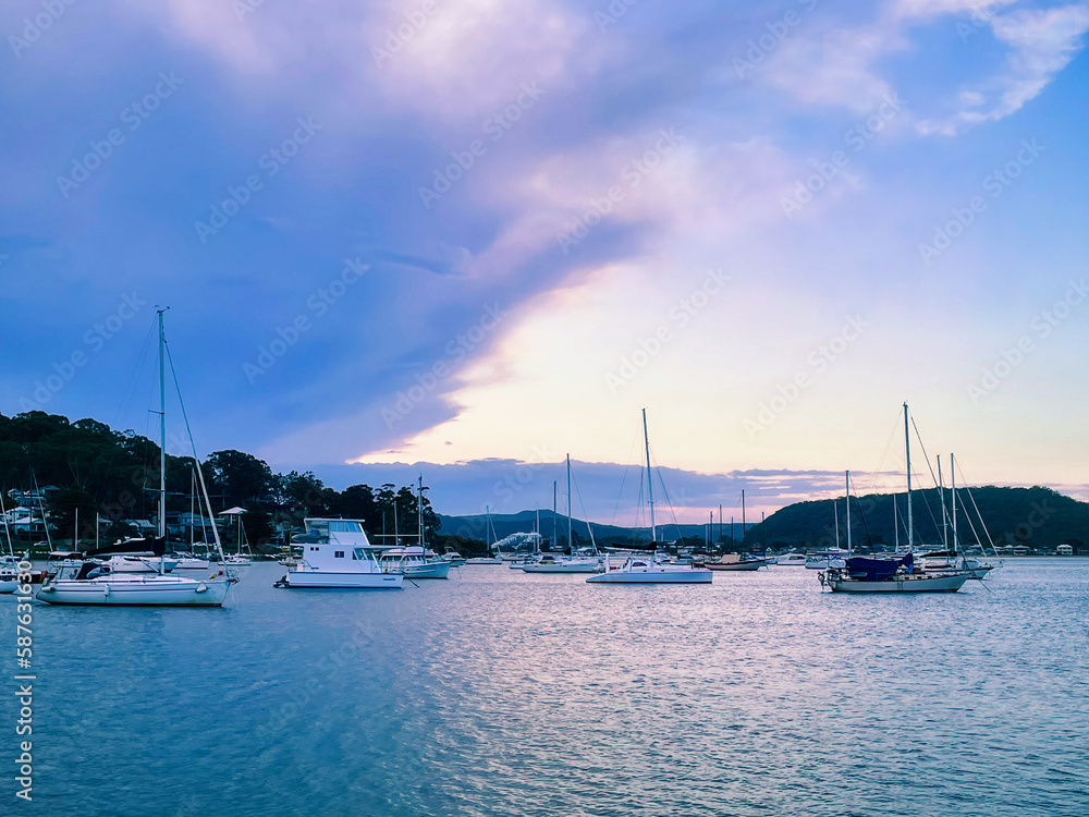 Beautiful scenery at sunset in the small resort town of Killcare with boats on the water in the foreground on the Central Coast, NSW, Australia.