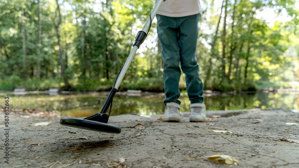 a boy with a metal detector in the park a boy with a metal detector in the park