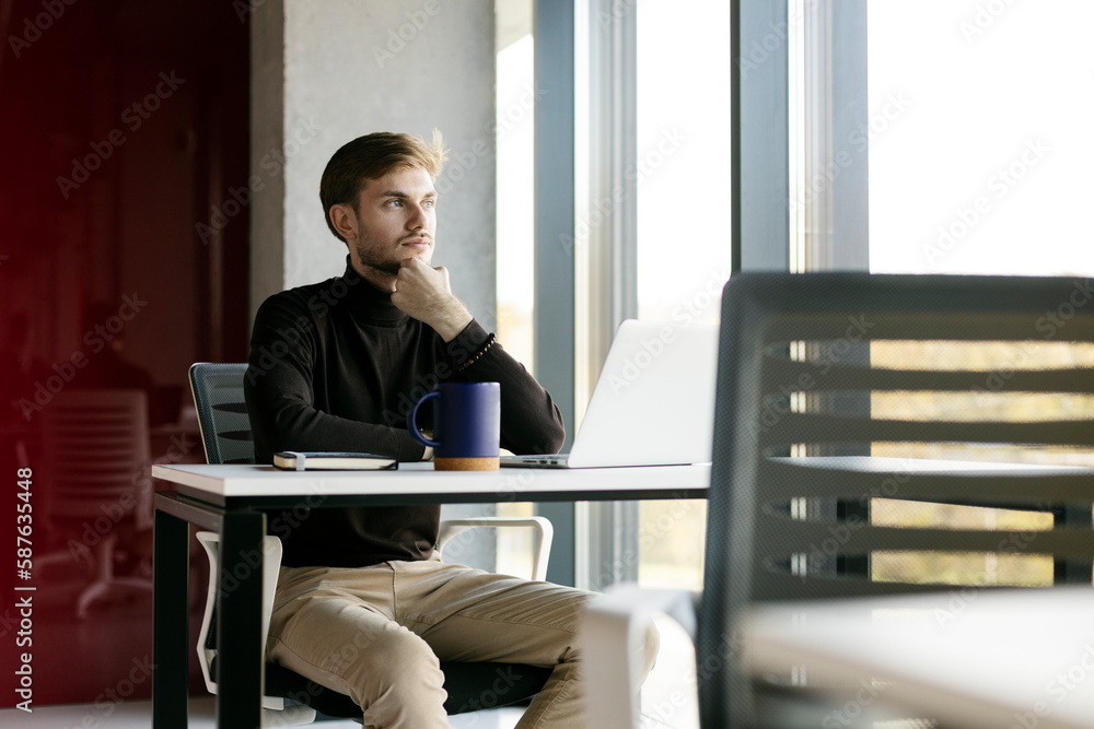 Portrait of attractive businessman, using laptop, man working online, looking away Portrait of attractive businessman, using laptop, man working online, looking away