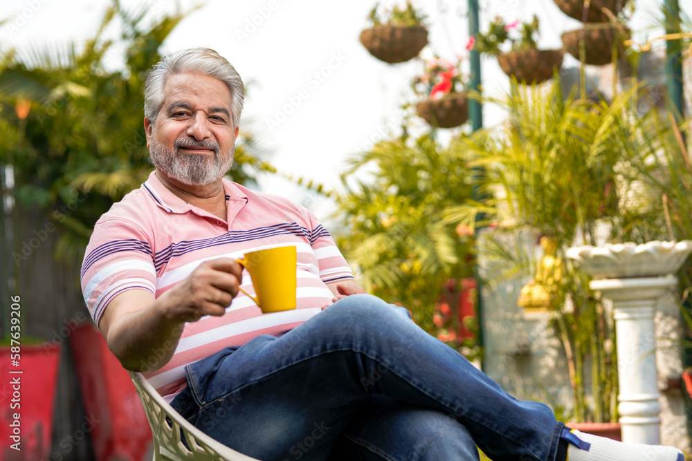 Happy senior man drinking a cup of coffee or tea in his garden. Happy senior man drinking a cup of coffee or tea in his garden.