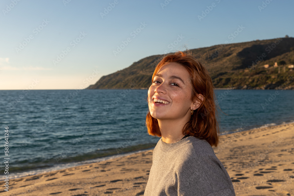 red-haired girl looking at the camera, on the beach red-haired girl looking at the camera, on the beach