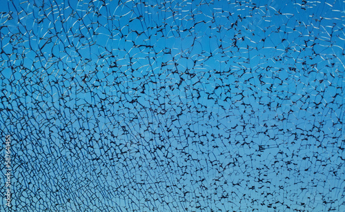 Blue broken cracked shattered window glass with black cracks