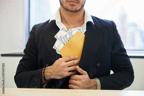 close up the man putting money in envelope into his suit pocket photo