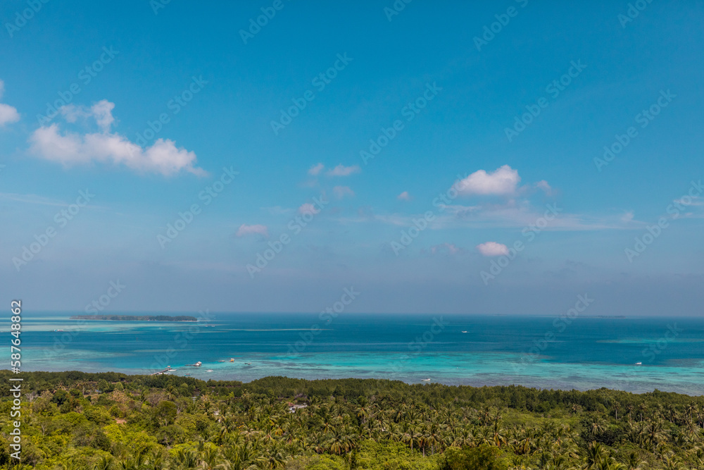Tropical landscape of Indonesian island Karimunjava with jungle and turquoise lagoon in the distance. 