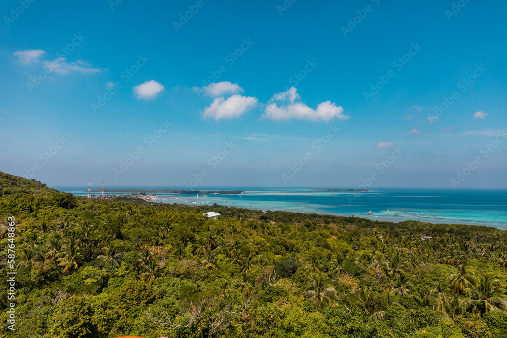 Tropical landscape of Indonesian island Karimunjava with jungle and turquoise lagoon in the distance. 