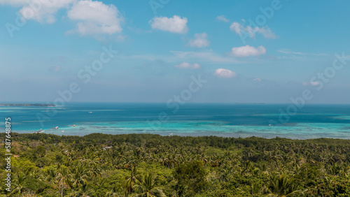 Tropical landscape of Indonesian island Karimunjava with jungle and turquoise lagoon in the distance.  photo