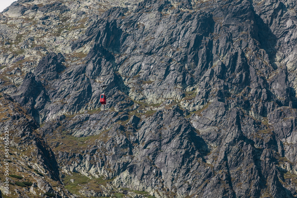 Obraz premium Red mountain cable car going up to the top of Lomnica Peak (Lomnický Peak, Lomnický štít ) in beautiful alpine High Tatras in Slovakia 