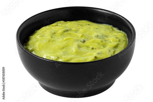 Guacamole dip in a black ceramic bowl isolated.