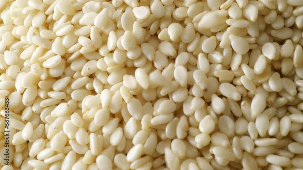 White sesame seed falling. Macro shot. White sesame seed falling. Macro shot.