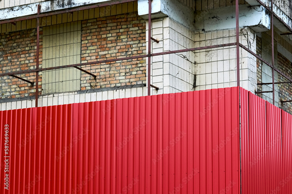Sheathing of a building construction being repaired a metal red sheet profile Sheathing of a building construction being repaired a metal red sheet profile