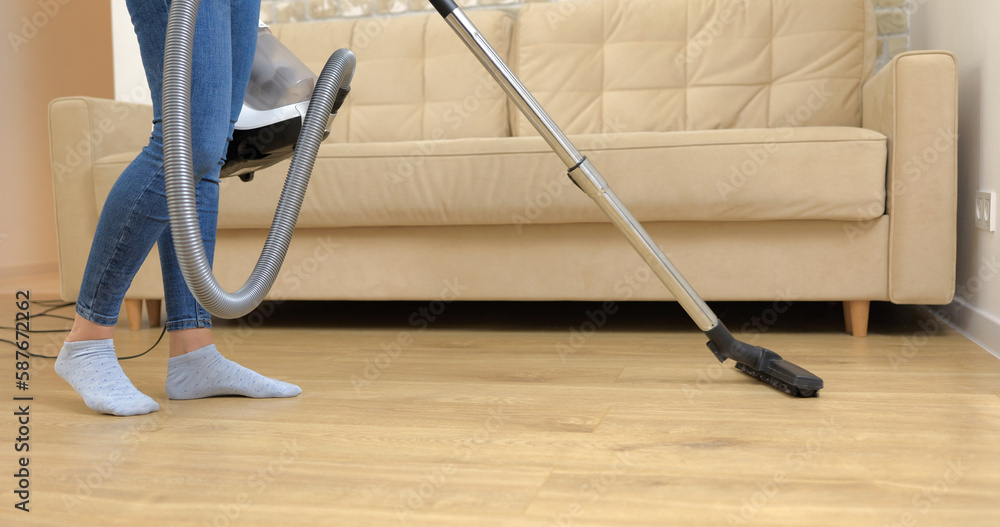 Fototapeta premium Young Woman cleaning Her house with Vacuum Cleaner