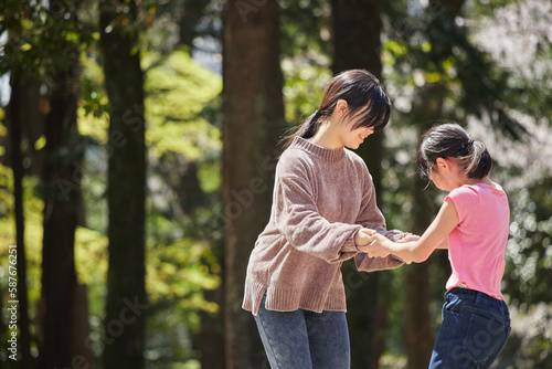 春の公園で遊んでいる子供姉妹の様子