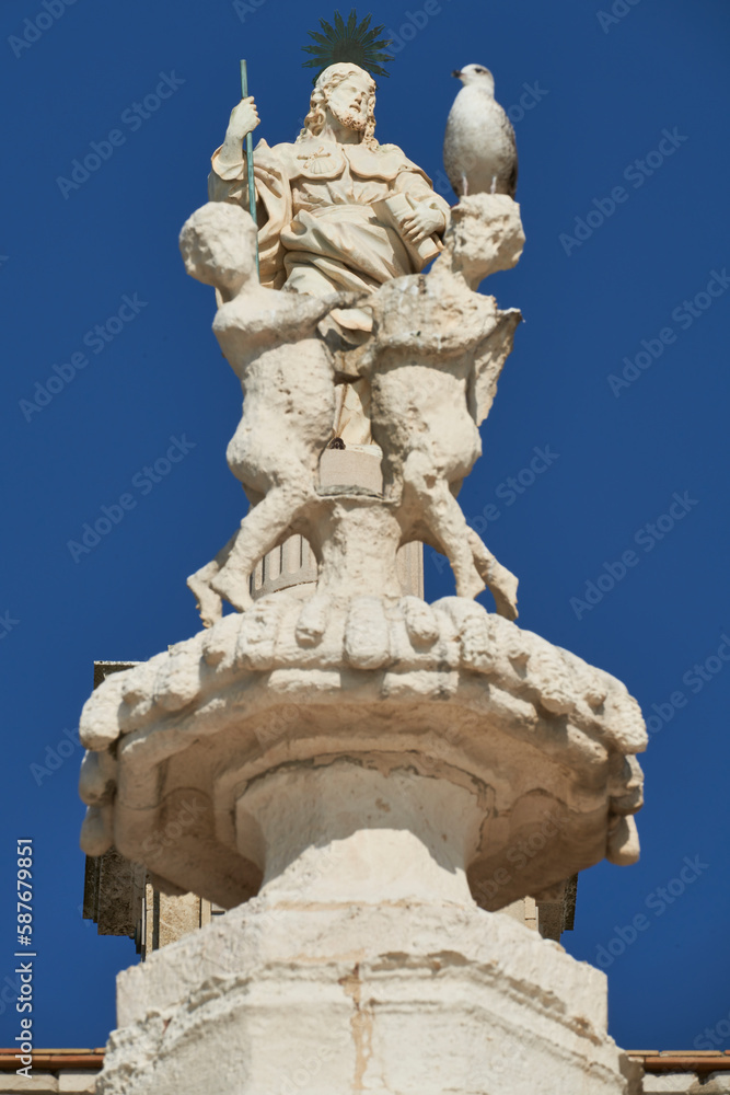 These are actually two different statues. In the foreground the group of two angels and in the background, on top of the dome of the cathedral, the statue of Christ. Cadiz, Spain