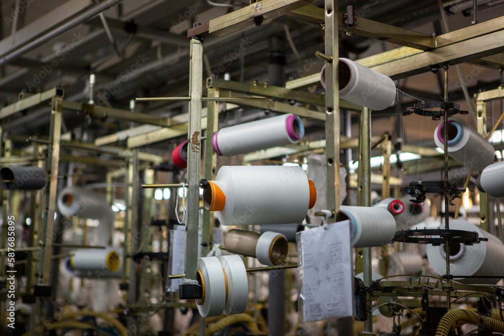 Textile industry with knitting machines in factory. Textile industry with a loom on the production of kapron tights.