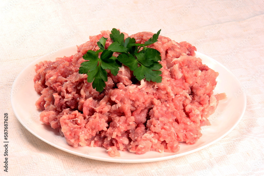 Ground pork on a plate decorated with green parsley leaves Ground pork on a plate decorated with green parsley leaves