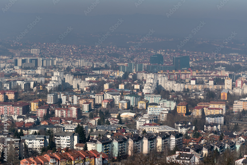 Cityscape of Banja Luka during sunny day, distant hill fade in hazy polluted air