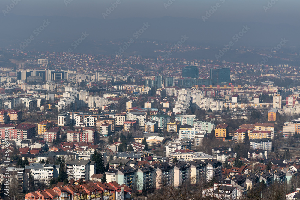 Fototapeta premium Cityscape of Banja Luka during sunny day, distant hill fade in hazy polluted air