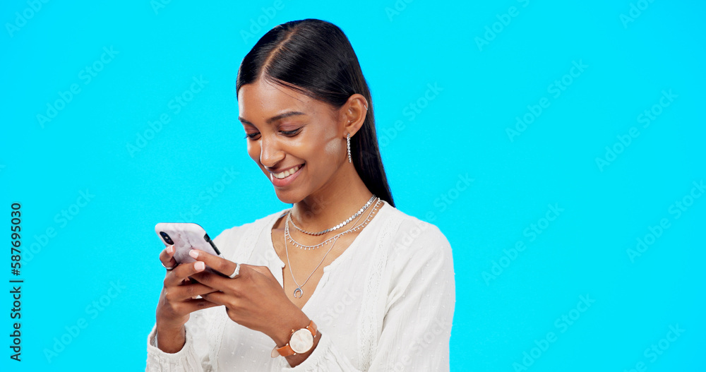 © Nina/peopleimages.com - Phone, typing and young woman isolated on blue background for social media post, networking and chat tech. Happy indian person or online user with mobile app, smartphone or cellphone in studio mockup © Nina/peopleimages.com - Phone, typing and young woman isolated on blue background for social media post, networking and chat tech. Happy indian person or online user with mobile app, smartphone or cellphone in studio mockup