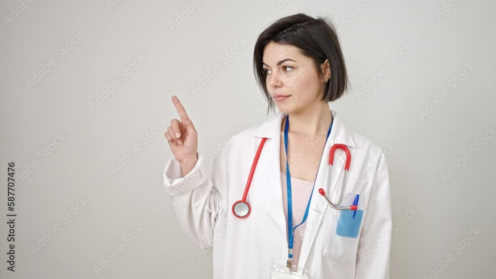Young caucasian woman doctor pointing with finger to the side over isolated white background Young caucasian woman doctor pointing with finger to the side over isolated white background
