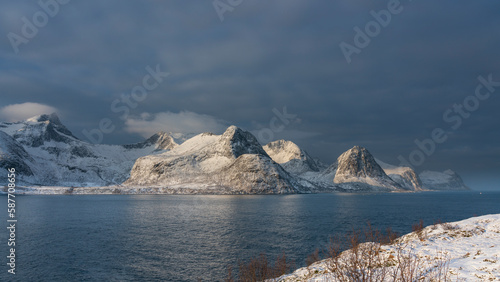 Øyfjorden im Morgenlicht, mit den schneebedeckten Bergen von Senja, genannt Segla, Kongan und Skultran im Hintergrund. Norwegen im Winter, mit Atlantik und Fjord  photo