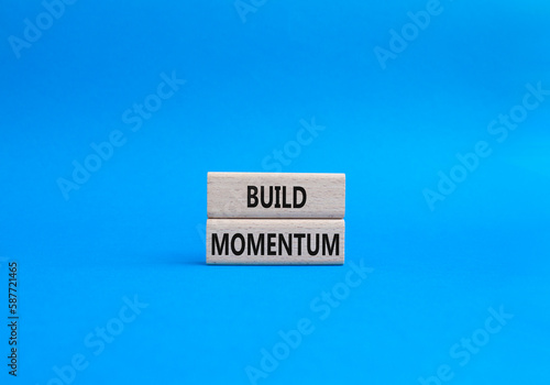 Build momentum symbol. Wooden blocks with words Build momentum. Beautiful blue background. Business and Build momentum concept. Copy space.