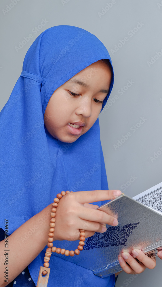 Fototapeta premium Pretty Muslim Girl Studying Holy Book of Quran