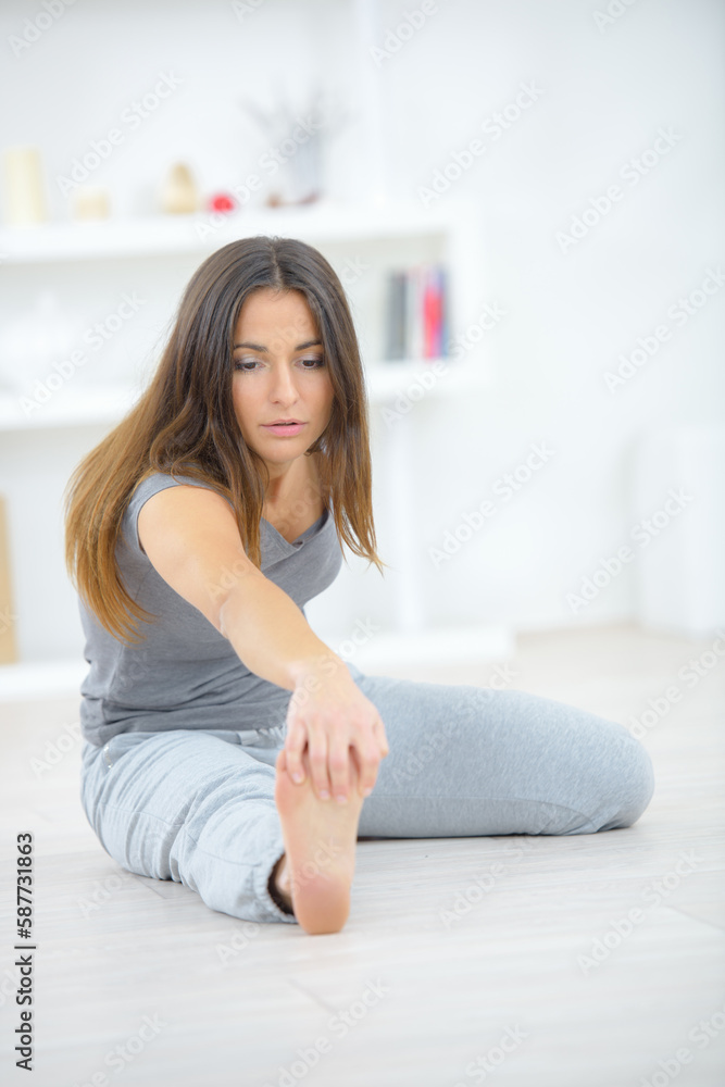 Lady exercising, holding her toes