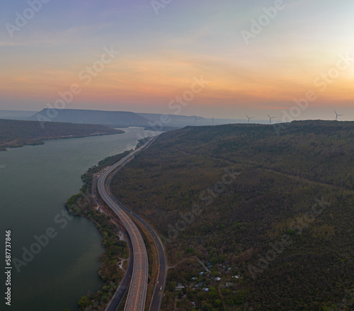 .aerial view light on super highway Along the Lam Takhong Dam at twilight..view of natural scenery beside the road..dams and wind turbines that generate electricity..blue water and beautiful sky © Narong Niemhom