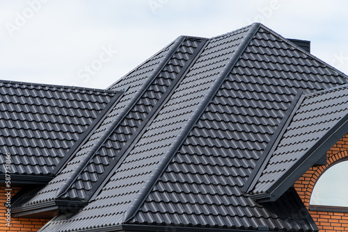 House with a black metal roof. Corrugated metal roof and metal roofing